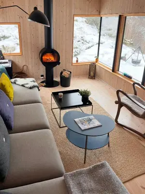 a living room with a couch and a fire place at Architect Drawn Cabin Between Sea And Mountain in Hosen