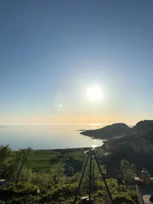a view of the sun setting over the ocean at Architect Drawn Cabin Between Sea And Mountain in Hosen