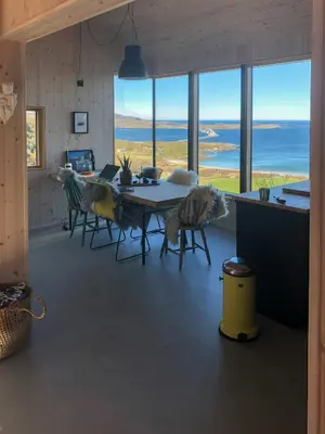 a dining room with a table and chairs and the ocean at Architect Drawn Cabin Between Sea And Mountain in Hosen