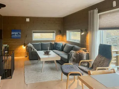 a living room with a couch and a table at Modern Family Cabin At Sjusjøen in Sjusjøen