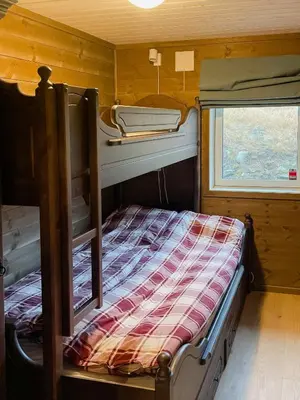 a bunk bed in a small room with a window at Modern Family Cabin At Sjusjøen in Sjusjøen