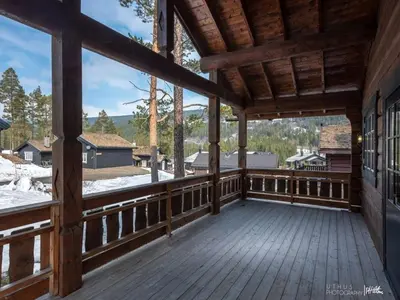 a large wooden porch with a view of the mountains at Spacious Log Cabin Near Hardangervidda in Uvdal