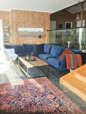 a living room with a blue couch and a coffee table at Sunny Cabin With Panoramic Views At Sjusjøen in Sjusjøen