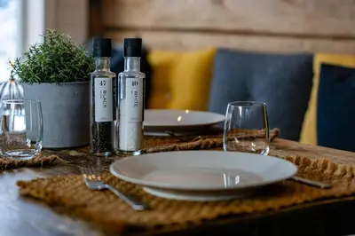 a table with two wine bottles and plates and glasses at Charming House In Loen, In The Heart Of Nordfjord in Loen