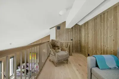 a room with wooden walls and a rocking chair at Cosy Apartment With Ski Inout In Hafjell in Øyer