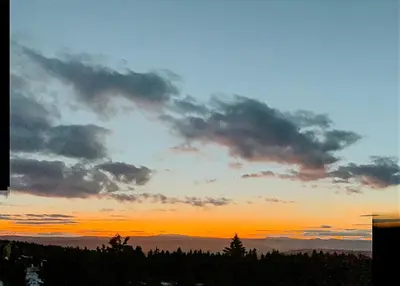 a sunset with clouds in the sky and trees at Cosy Apartment With Ski Inout In Hafjell in Øyer