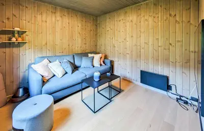 a living room with a blue couch and a table at Spacious Familyabin With A View On Norefjell in Noresund