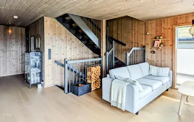 a living room with a couch and a staircase at Spacious Familyabin With A View On Norefjell in Noresund