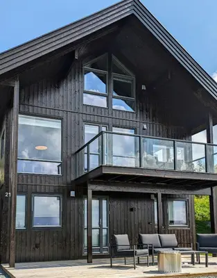 a large house with a balcony and windows at Spacious Familyabin With A View On Norefjell in Noresund