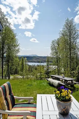 a patio with a table and chairs and a view of a lake at Mountain Cabin With Great Views in Austbygdi
