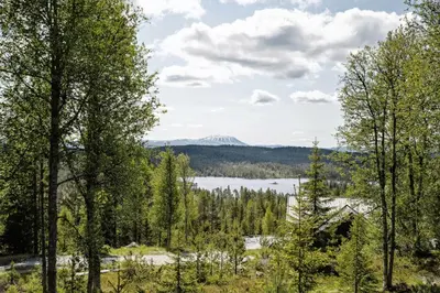 a view of a lake through the trees at Mountain Cabin With Great Views in Austbygdi