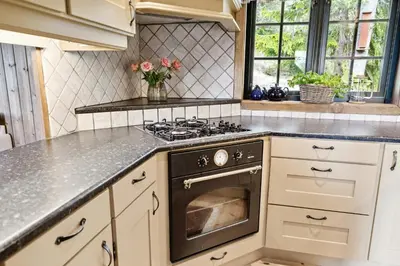 a kitchen with white cabinets and a stove top oven at Mountain Cabin With Great Views in Austbygdi