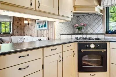 a kitchen with white cabinets and a black oven at Mountain Cabin With Great Views in Austbygdi