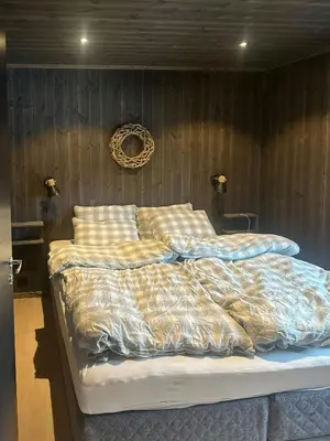 a bedroom with a bed with a comforter and pillows at Idyllic Cabin With Panoramic Mountain Views in Nerskogen