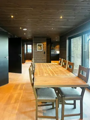 a dining room with a large wooden table and chairs at Idyllic Cabin With Panoramic Mountain Views in Nerskogen