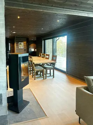 a dining room with a table and a fireplace at Idyllic Cabin With Panoramic Mountain Views in Nerskogen