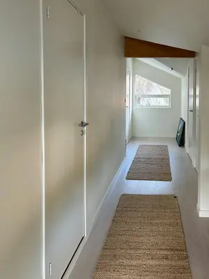 a hallway with white walls and a sliding glass door at Charming Seaside Cabin With Views Over The Water