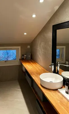 a bathroom with a large sink and a mirror at Charming Seaside Cabin With Views Over The Water