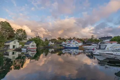a group of boats are docked in a harbor at Kulleseidkanalen gjestehamn in Bømlo