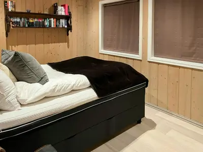 a bed sitting in a room with a window at Mountain Cabin With Sauna, Jacuzzi And Views in Nord Torpa