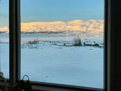 a view of a snow covered field from a window at Modern Mountain Cabin With Nature In Valdres in Løken