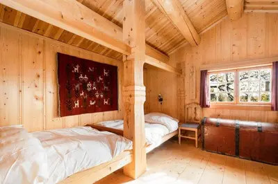 a bedroom with two beds in a log cabin at Mountain Cabin With Wood-Fired Sauna And A View in Golsfjellet