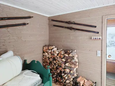 a wall with a pile of fire wood in a room at Mountain Cabin With Wood-Fired Sauna And A View in Golsfjellet