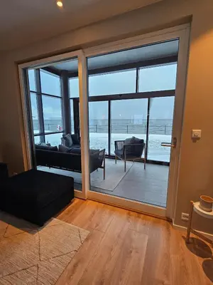 a living room with a large sliding glass door at Stor og ny leilighet med fjordutsikt in Sande