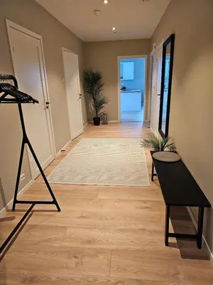 a hallway of a home with a table and a chair at Stor og ny leilighet med fjordutsikt in Sande