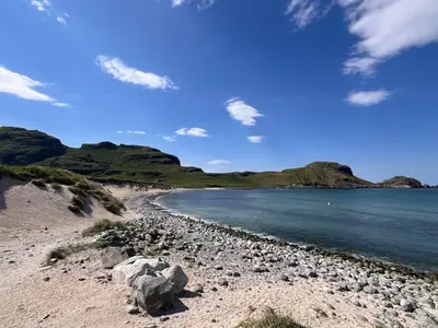 a beach with rocks and the water and mountains at Stor og ny leilighet med fjordutsikt in Sande