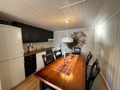 a kitchen with a table with chairs and a refrigerator at Cozy Two Bedrooms Apartment With Sauna And Mountain Views in Beitostøl