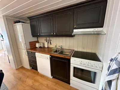 a small kitchen with black cabinets and a sink at Cozy Two Bedrooms Apartment With Sauna And Mountain Views in Beitostøl