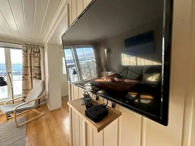 a living room with a large flat screen tv on the wall at Cozy Two Bedrooms Apartment With Sauna And Mountain Views in Beitostøl