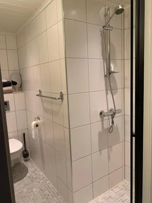a shower with a glass door in a bathroom at Central and modern apartment in Hamar
