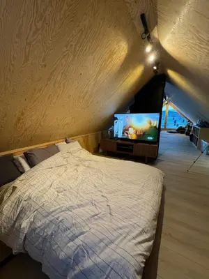 a bedroom with a bed and a flat screen tv at Lodge Orkanger - Spacious Comfort - Designed for family moments in Orkanger