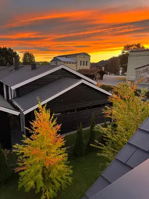 a view of a building with a sunset in the background at Lodge Orkanger - Spacious Comfort - Designed for family moments in Orkanger