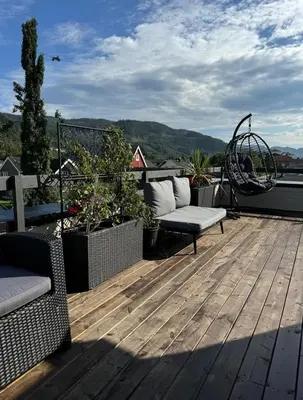a deck with a couch and chairs on a roof at Lodge Orkanger - Spacious Comfort - Designed for family moments in Orkanger
