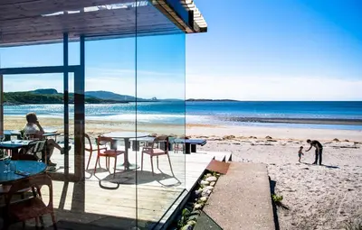 a view of the beach from a restaurant on the beach at Støkkøya Strandhotell in Hosen