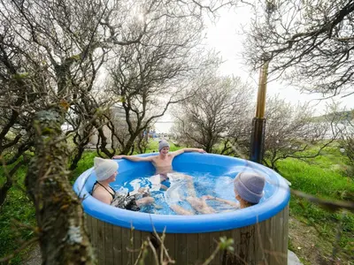 a group of three people in a hot tub at Støkkøya Strandhotell in Hosen
