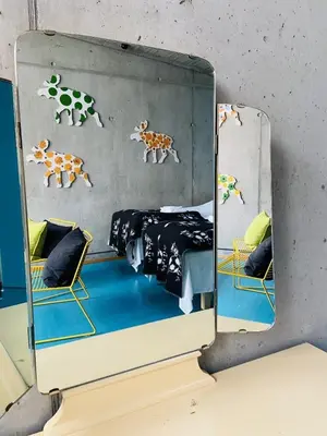 a mirror reflection of a bedroom with cows on the wall at Støkkøya Strandhotell in Hosen