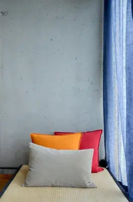 a bed with three pillows on it next to a wall at Støkkøya Strandhotell in Hosen