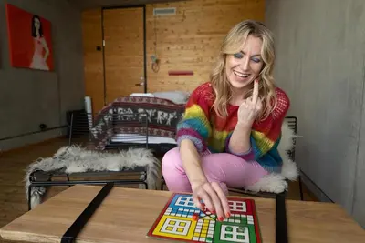 a woman is playing a board game on a table at Støkkøya Strandhotell in Hosen