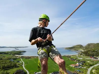a man in a helmet is hanging from a rope at Støkkøya Strandhotell in Hosen