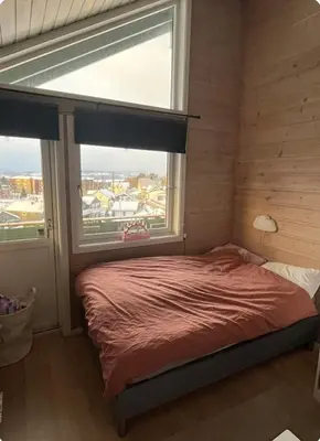 a bedroom with a bed and a large window at Utsikten in Trondheim