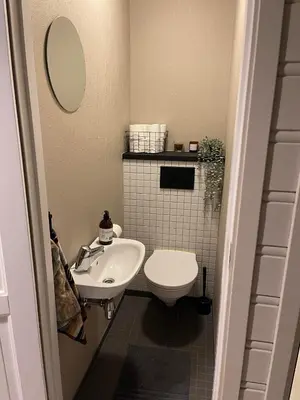a small bathroom with a toilet and a sink at Utsikten in Trondheim