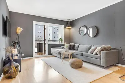 a living room with a couch and a table and mirrors at Central 4-bedroom by Lerkendal in Trondheim