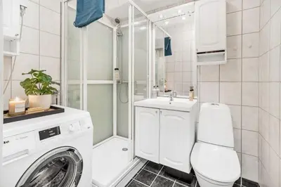 a bathroom with a washing machine and a sink at Central 4-bedroom by Lerkendal in Trondheim