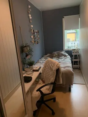a bedroom with a desk and a bed and a table at Central 4-bedroom by Lerkendal in Trondheim