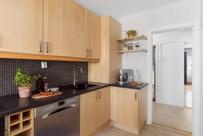 a kitchen with wooden cabinets and a sink at Sentral leilighet Trondheim in Trondheim