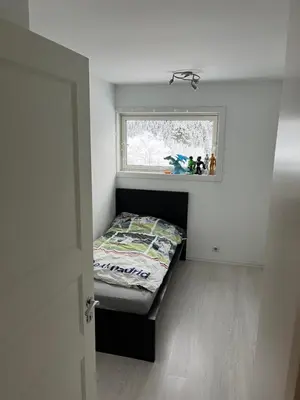 a small bedroom with a bed and a window at Ski VM in Trondheim